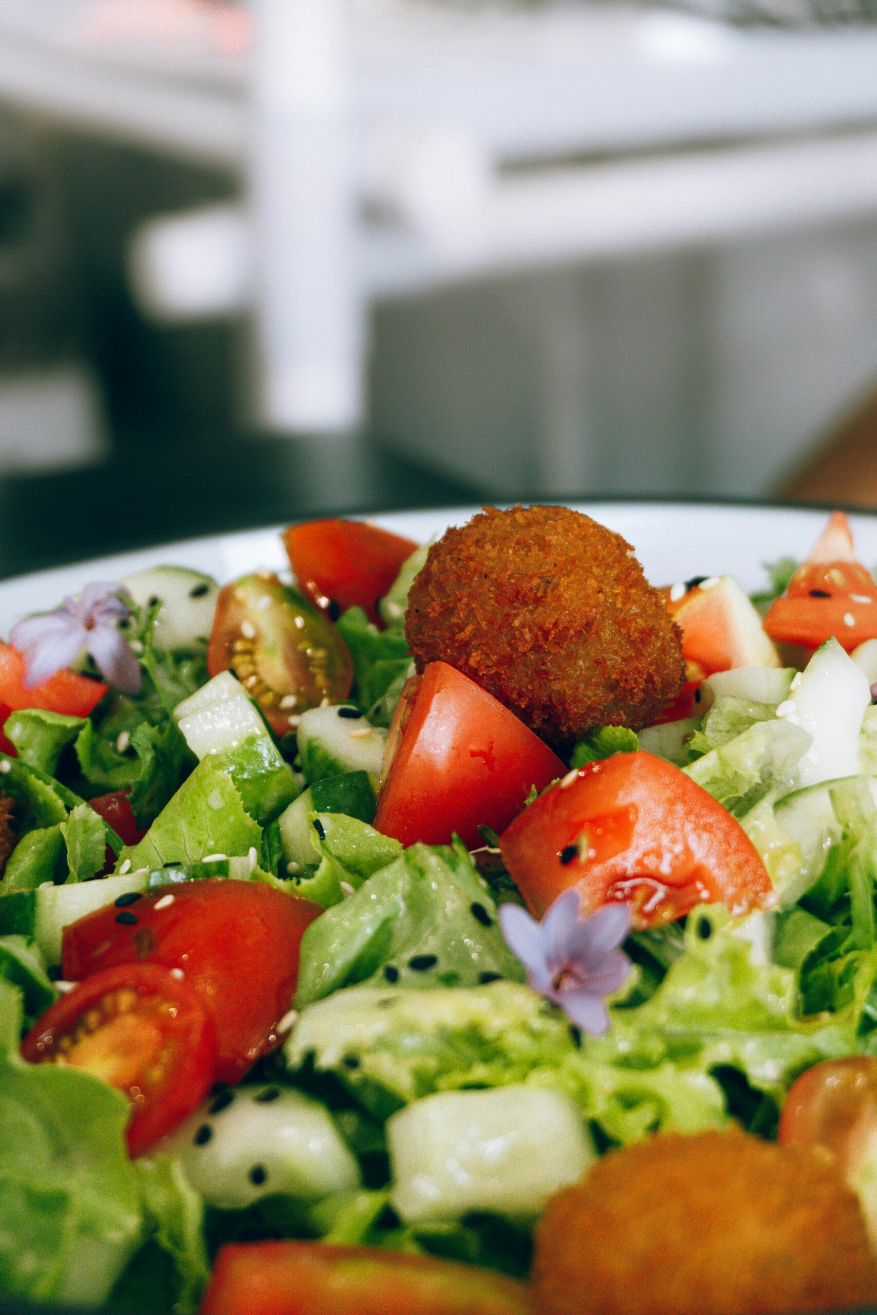 Writing Escape Tuscany Colorful garden salad with fresh veggies and crispy croquettes garnished with flowers, perfect for healthy meals.