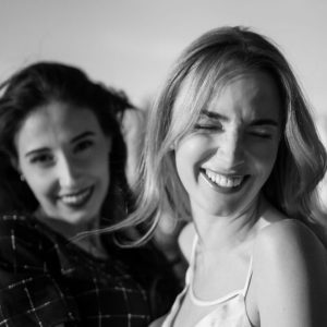 Two women smiling together in golden hour light
