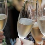 Friends raising glasses of sparkling wine in a toast to celebrate a milestone birthday in Tuscany